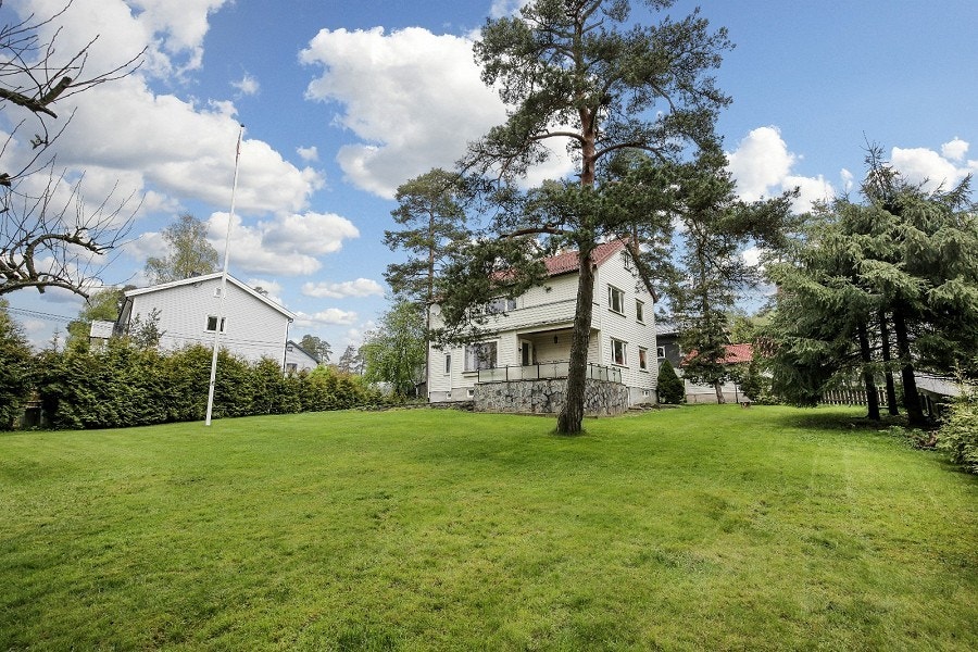 Huset er er omringet av stor hage, trær og grønne arealer. Galleribilde