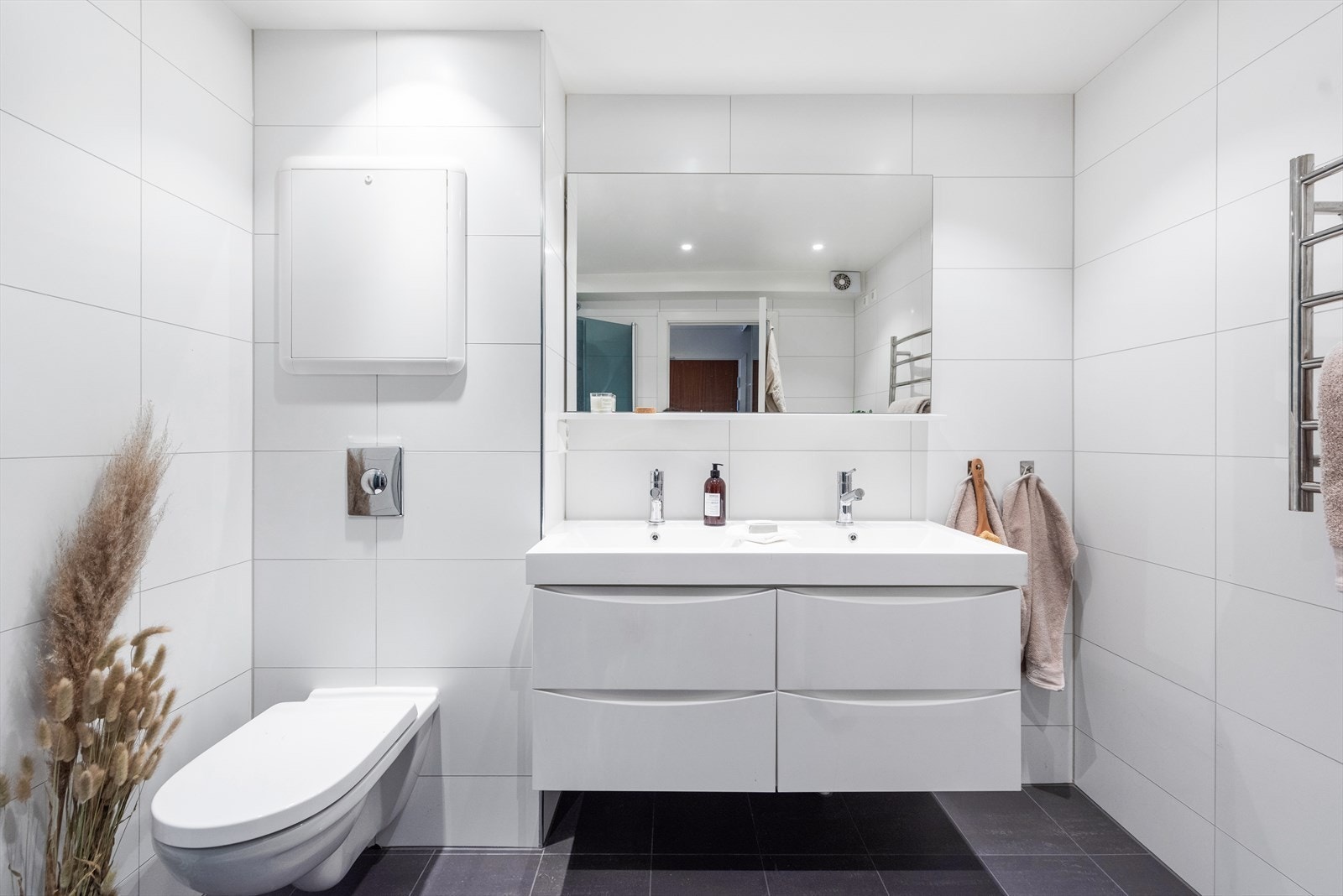 Lyst og pent bad fra 2015 med dobbeltservant, vegghengt toalett og varmekabler i gulv. Galleribilde