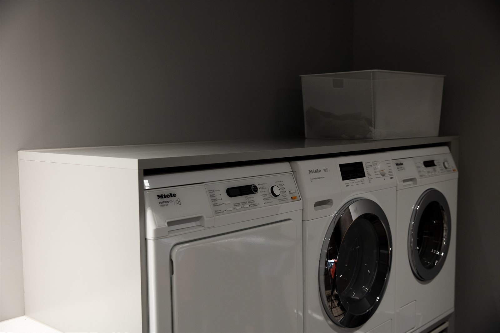 Vaskerommet har opplegg for to vaskemaskiner og en tørketrommel i god arbeidshøyde. Det er oppbevaringsskuffer under maskinene. Galleribilde