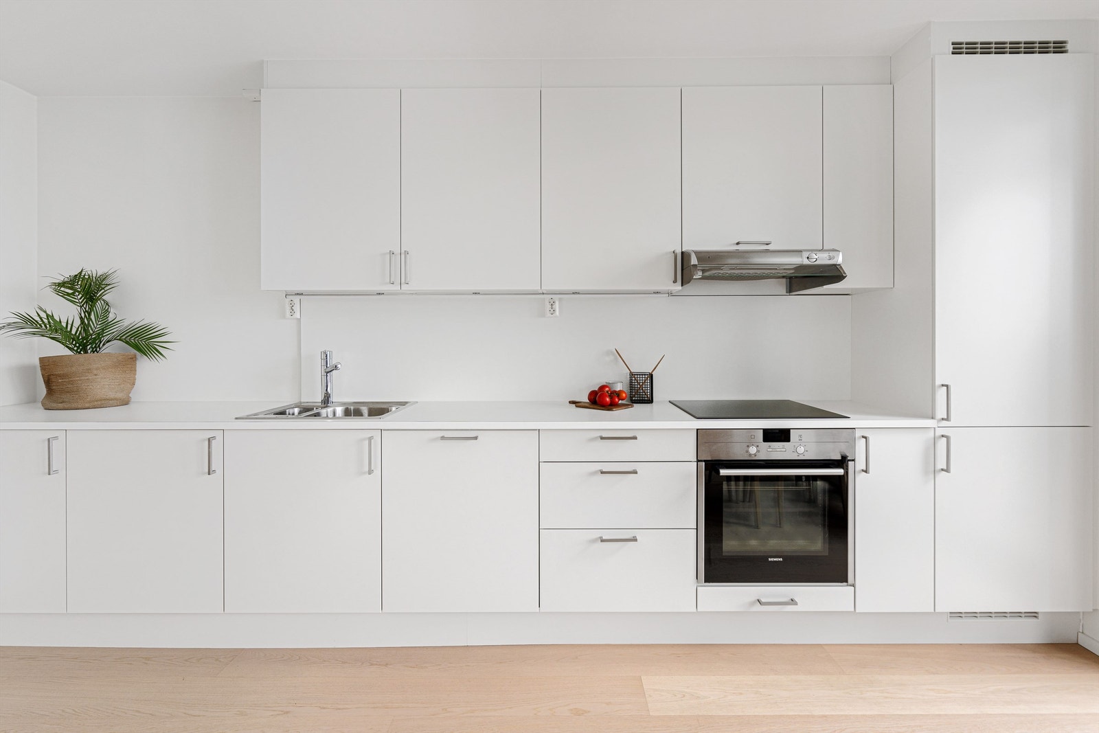 Lyst og lekkert kjøkken med hvitevarer Galleribilde