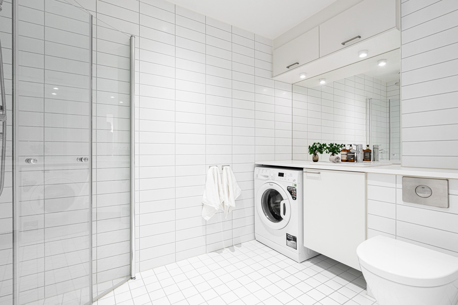 Flislagt bad med stort speil, benkeplate og servant Galleribilde