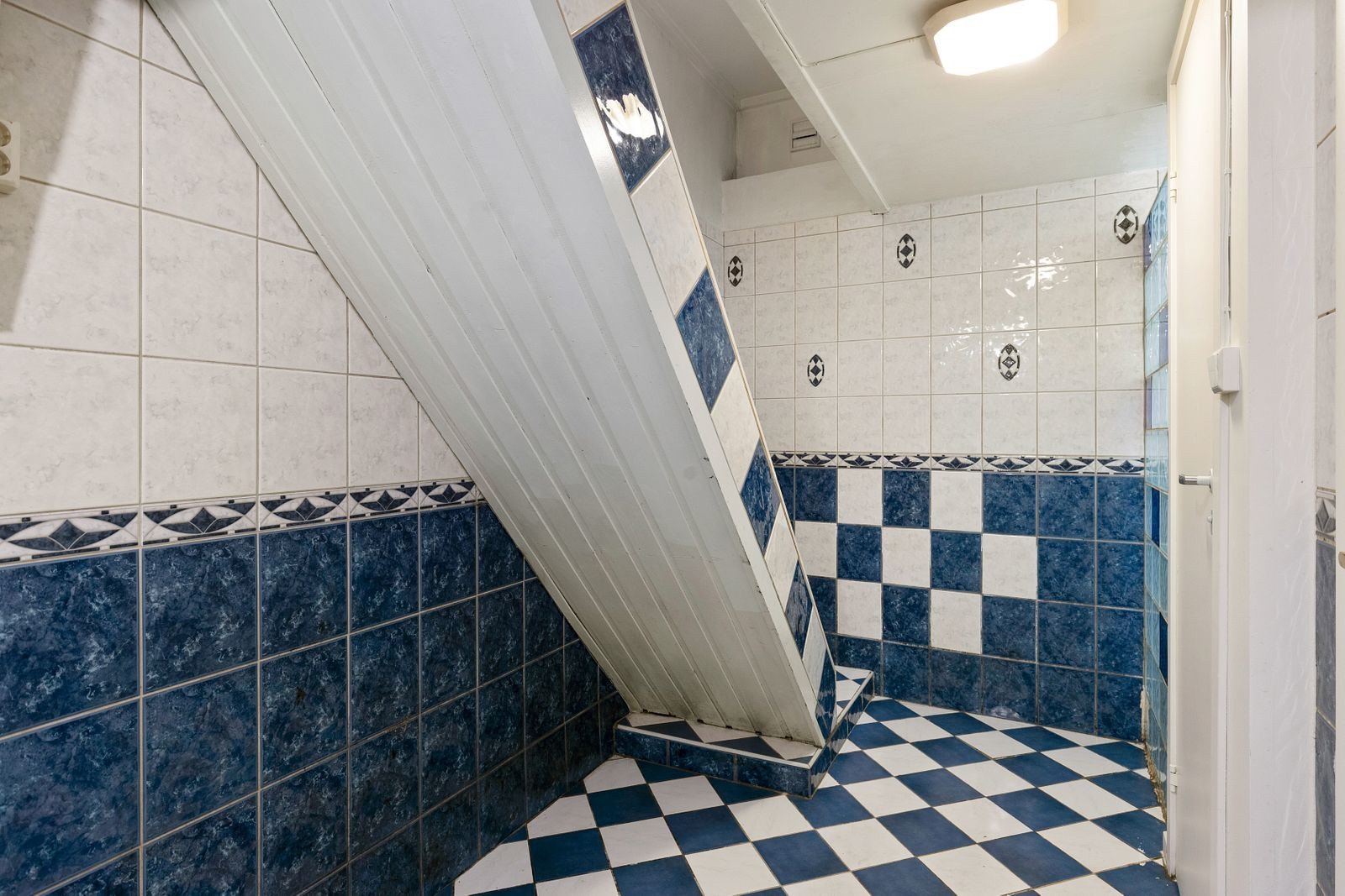 Trapp ned fra 1. etg til kjeller, gangen har samme kledelige fliser som på badet. Galleribilde