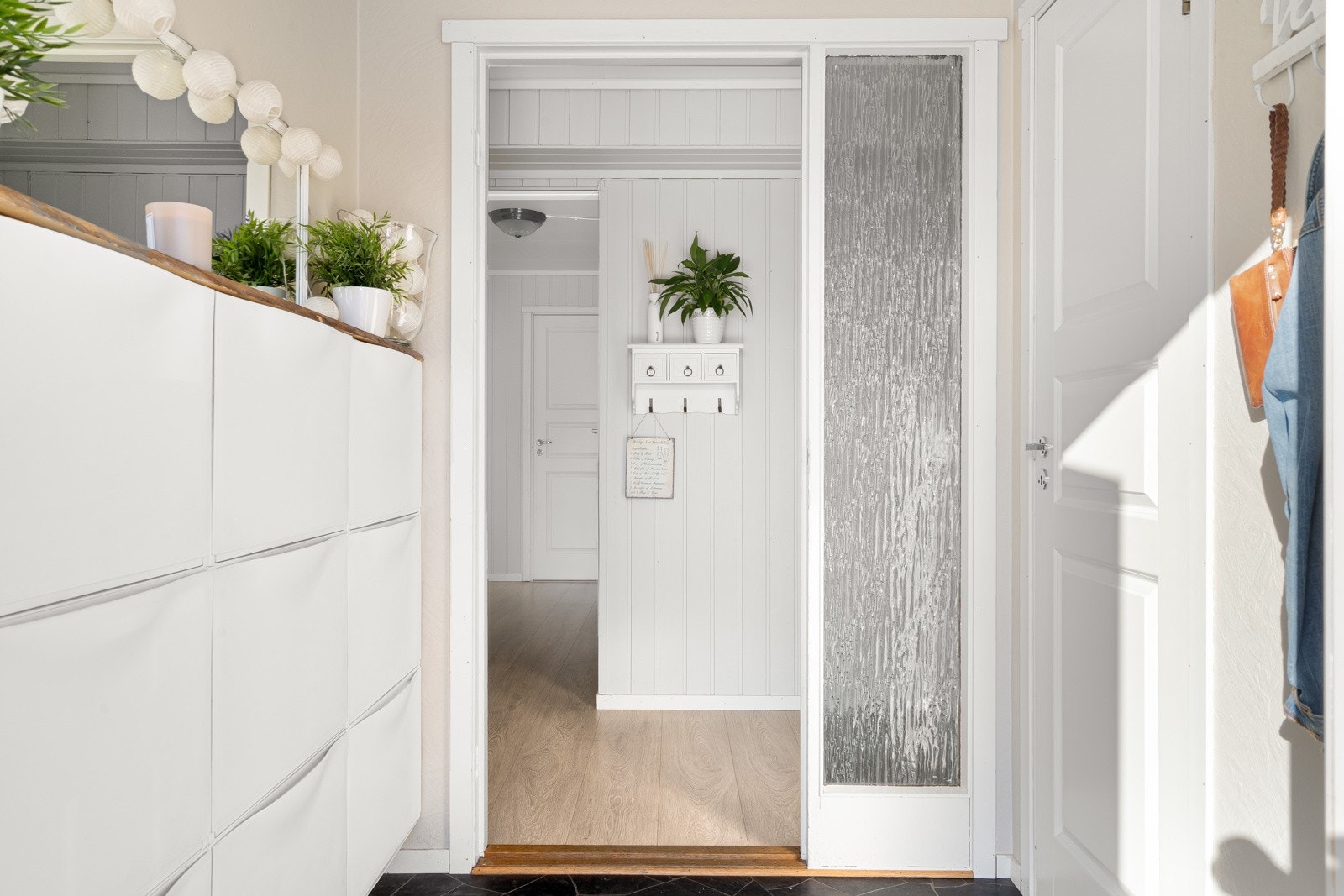 Lyst og innbydende inngangsparti med plass til oppbevaring av yttertøy- og sko Galleribilde