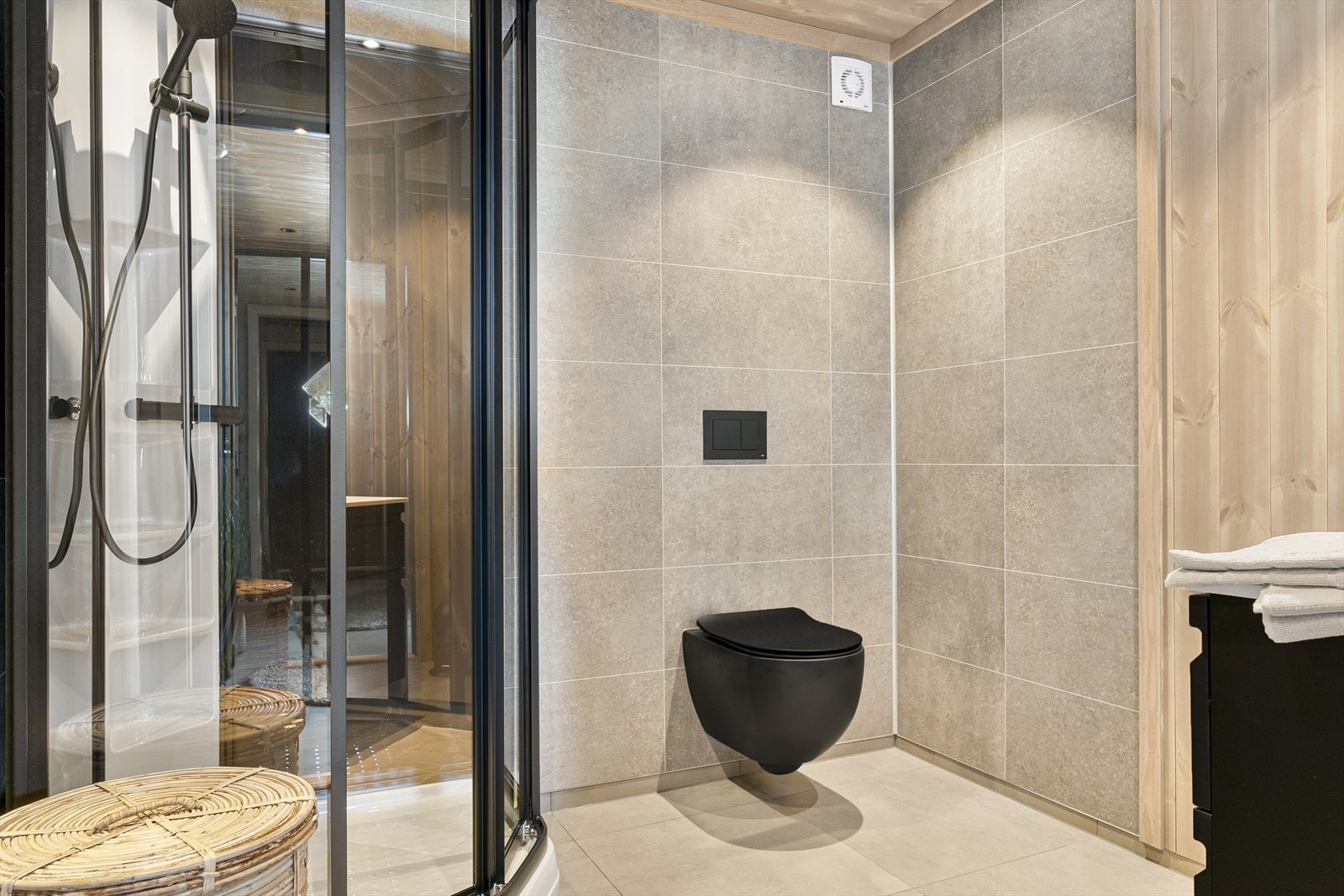 Baderommet har med dusjkabinett, toalett og baderomsinnredning i gjennomført stil Galleribilde