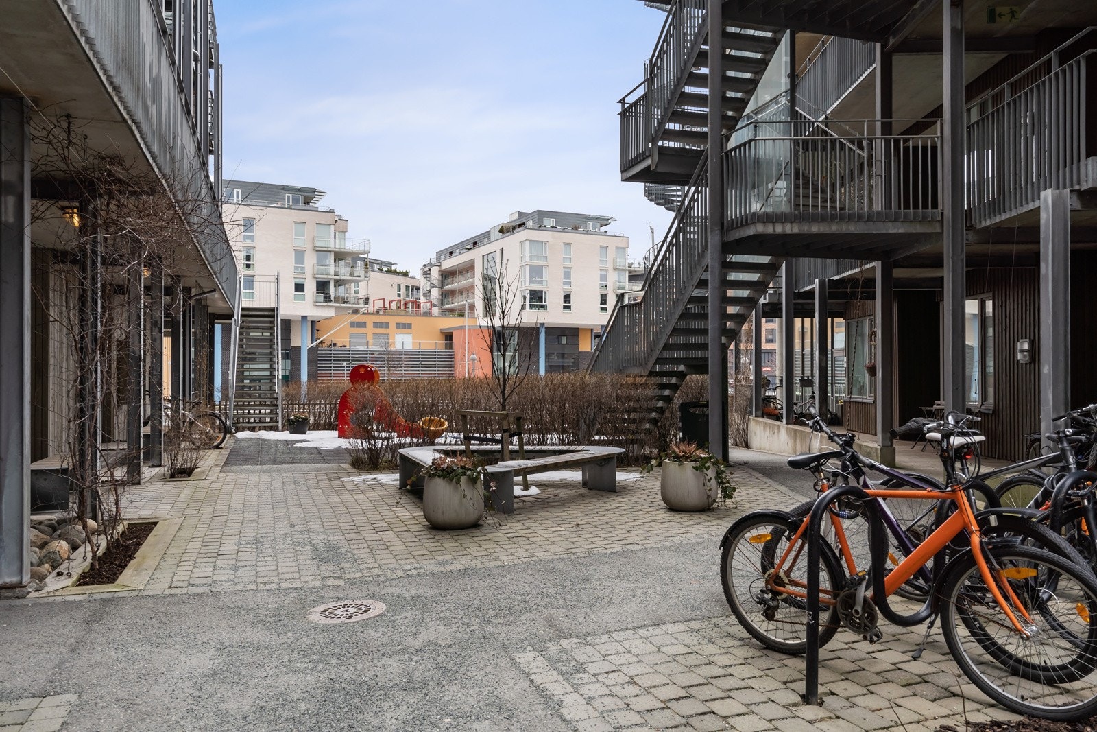 Skjermet bakgård med både sittegrupper og sykkelstativ mellom byggene Galleribilde