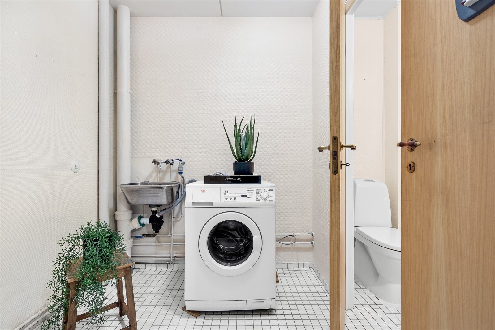 Separat vaskerom med utslagsvask og opplegg til vaskemaskin. Toalettrom innenfor vaskerom Galleribilde
