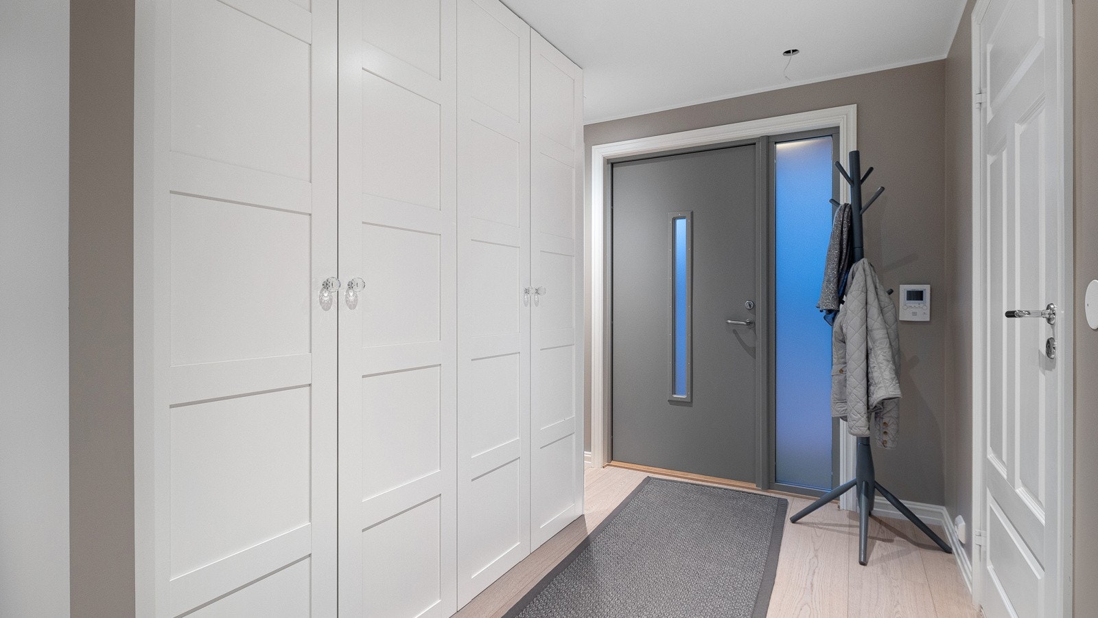 En lun og innbydende entré ønsker deg varmt velkommen med delikat fargepalett og dekorative detaljer Galleribilde