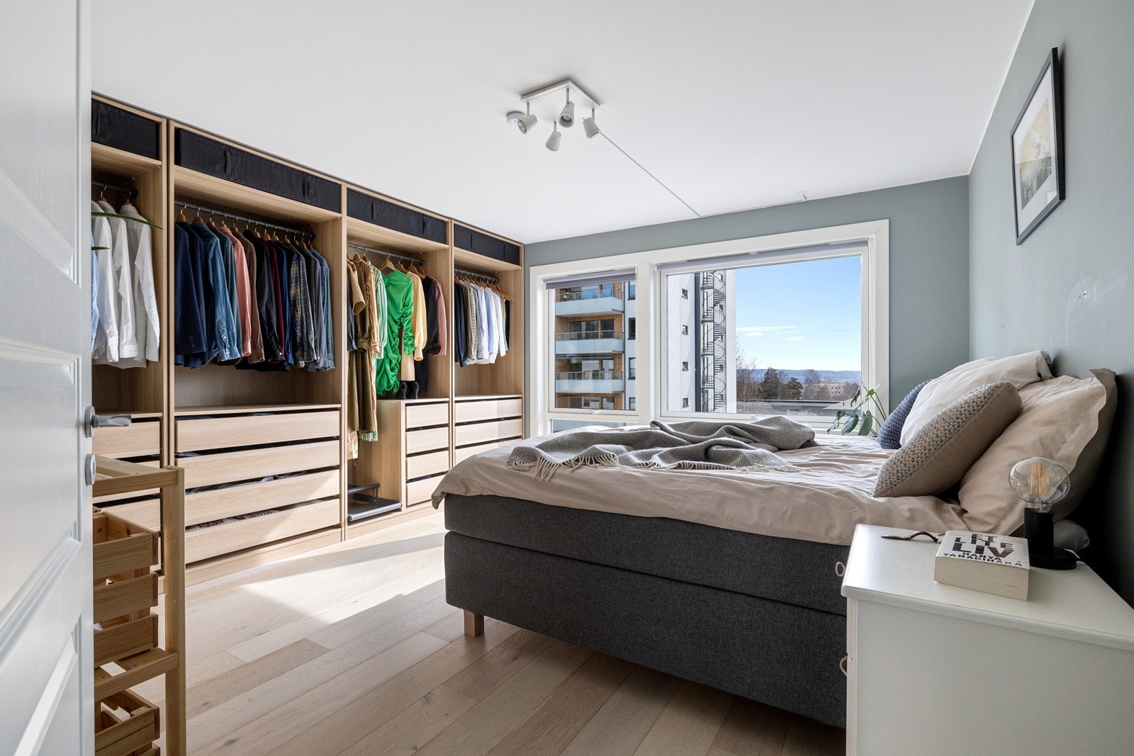 Stort hovedsoverom med rikelig oppbevaringsplass til klær i åpen garderobeløsning. Galleribilde