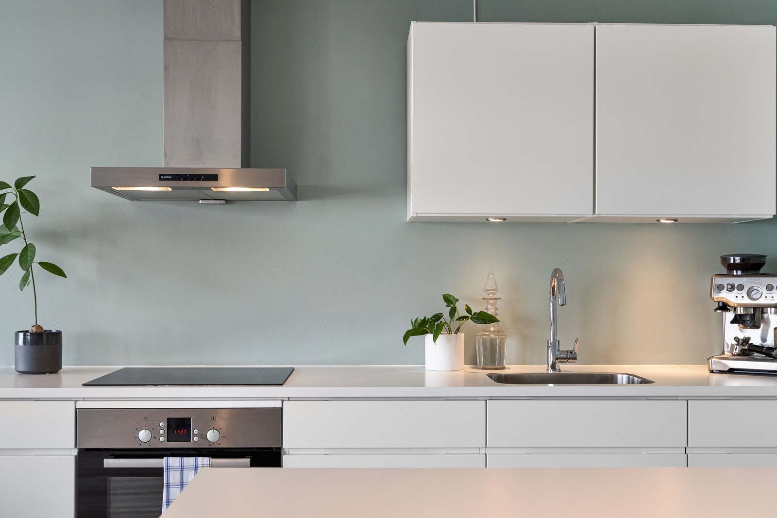 Kjøkkenet har et moderne uttrykk med håndtaksfrie skuffer og skap, samt belysning under benkeskap. Galleribilde