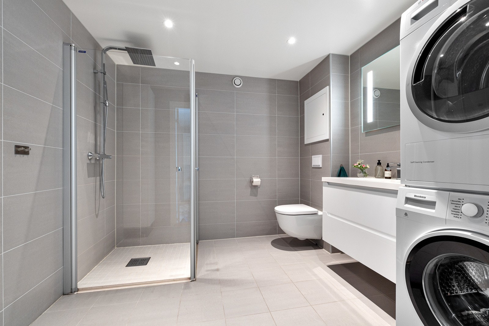 Stort og funksjonelt bad med gulvvarme og delikat flis- og innredningsvalg. Galleribilde