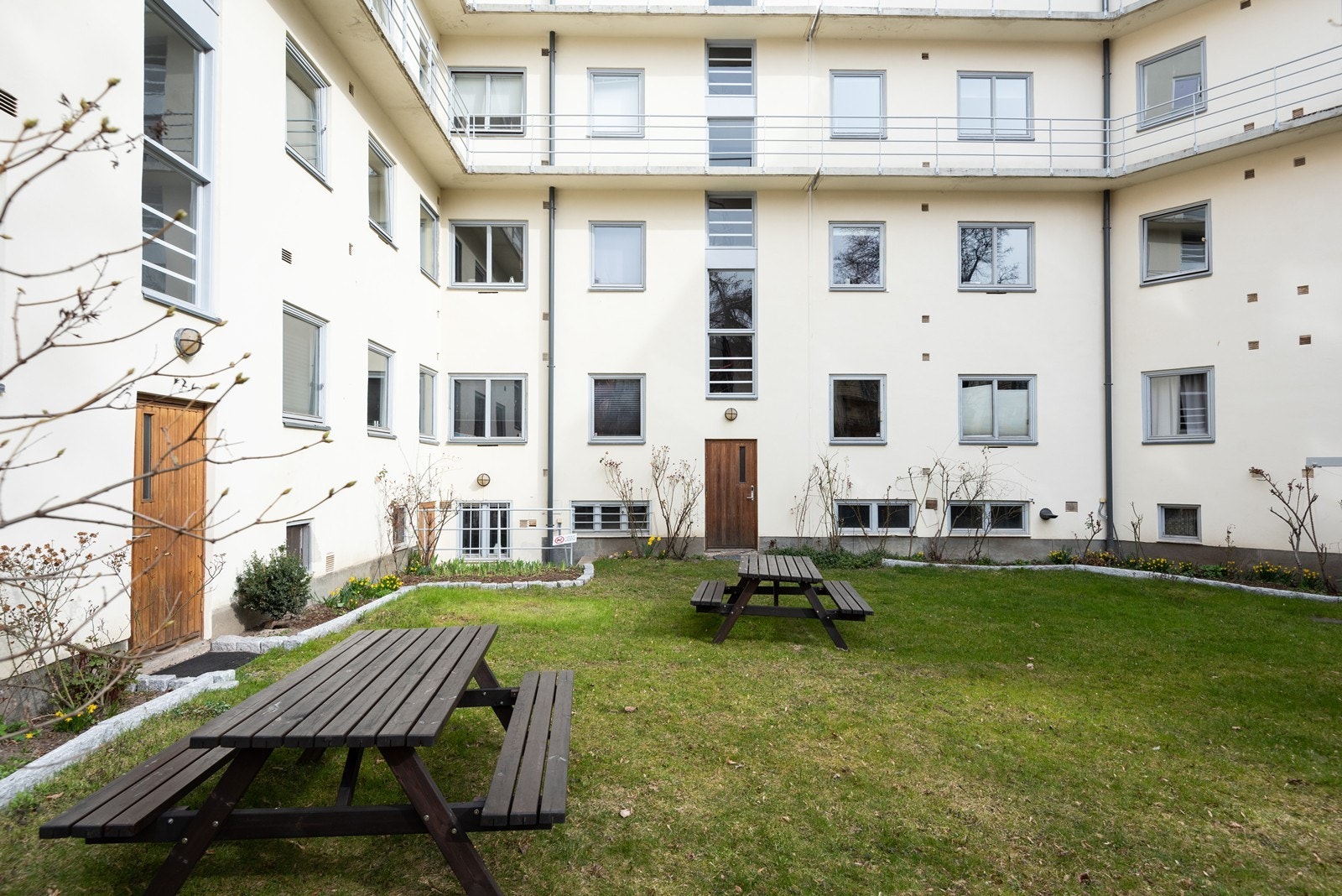 Koselig bakhage med sittegrupper og plen til bruk for beboerne. Galleribilde