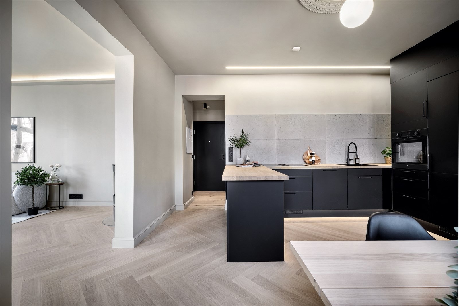 Kjøkken og spisestue belyses av skjult LED-stripe over kjøkkenbenk samt lampe hengende fra rosett. Galleribilde