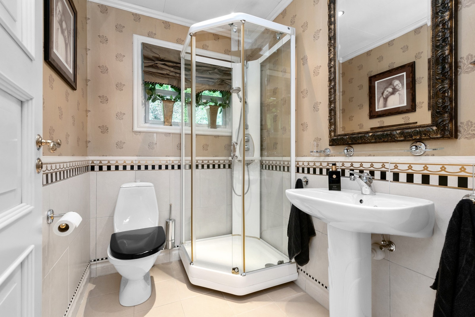 Baderom i hovedetasjen fra byggeår med flislagt gulv, flislagt brystning på vegger med overgang til tapet. Galleribilde