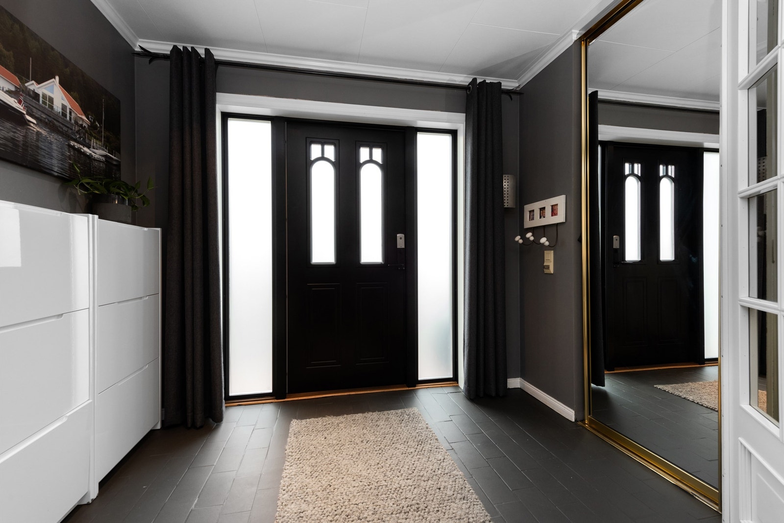 Boligen har entrédør med glassfelter og elektrisk kodelås. Galleribilde