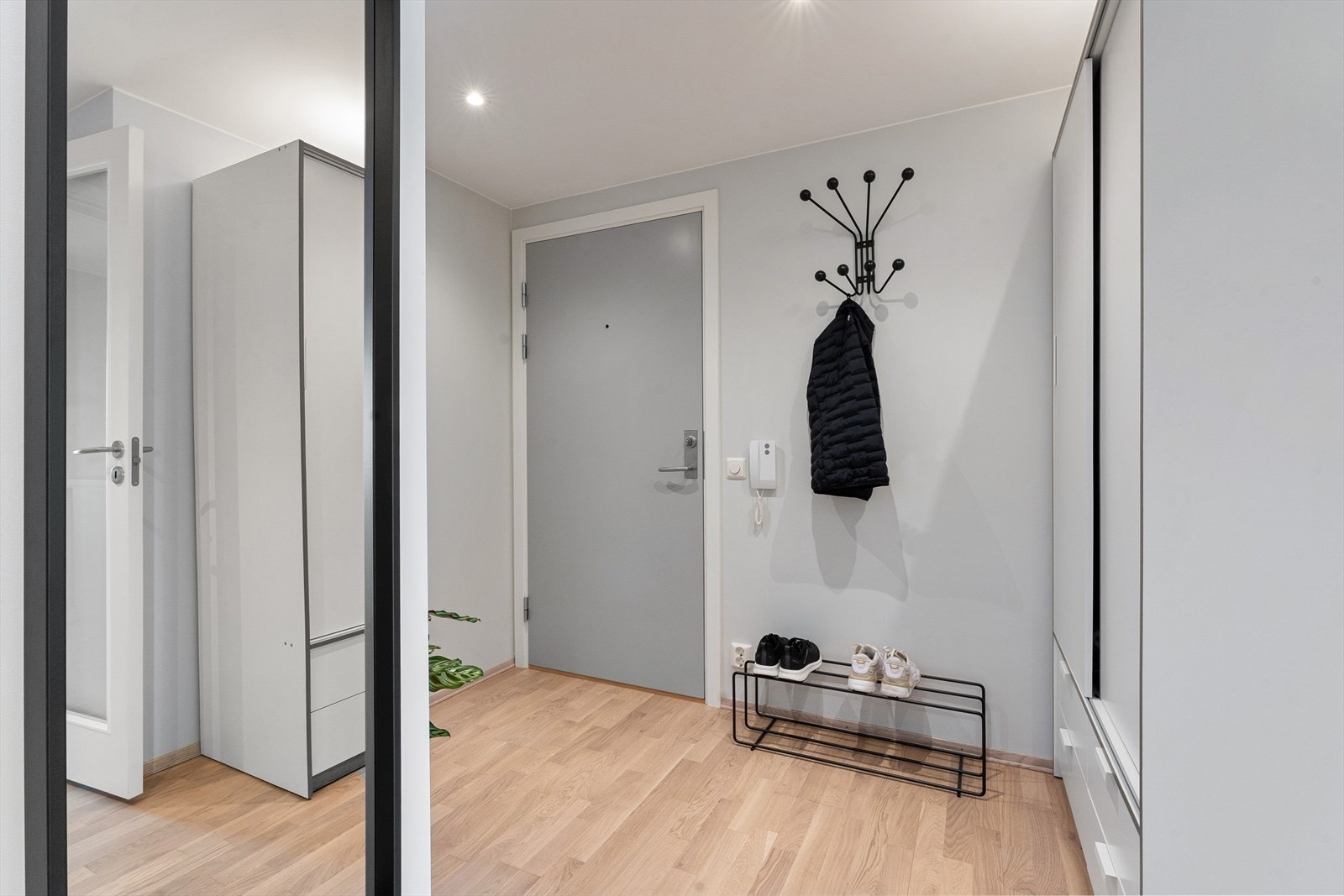 Det er godt med oppbevaringsplass i gangen med skyvedørsgarderobe og vegghengte knagger. Galleribilde