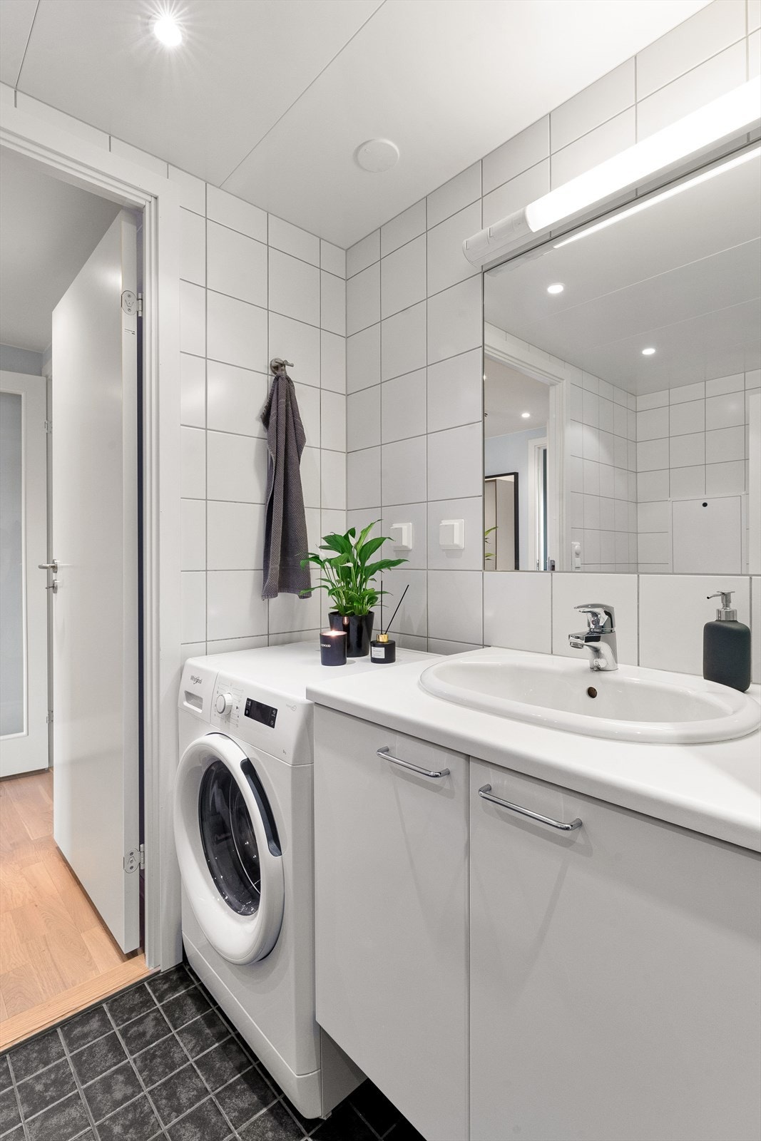 Badet har fliser på gulv med varme og flislagte vegger, opplegg for vaskemaskin og downlights i himling. Galleribilde