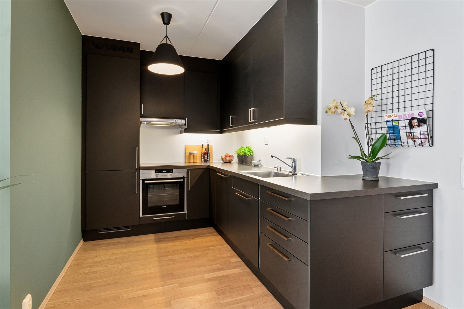 Kjøkkeninnredning med glatte fronter og laminat benkeplate med rustfri kum. Galleribilde