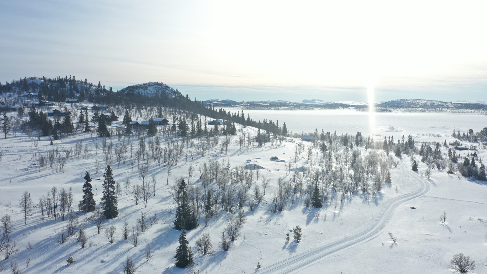 Hytteområdet med vannet Rødungen i bakgrunnen og skiløypene rett utenfor hytteveggen Galleribilde