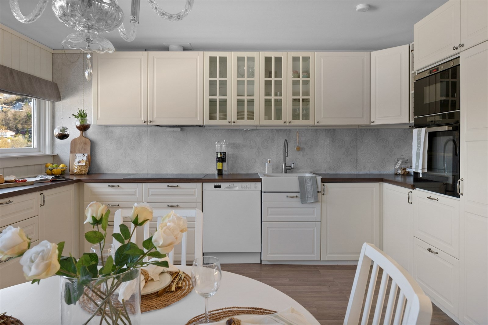 Stilrent og lekkert design med hvite profilerte fronter og takhøye overskap. Galleribilde