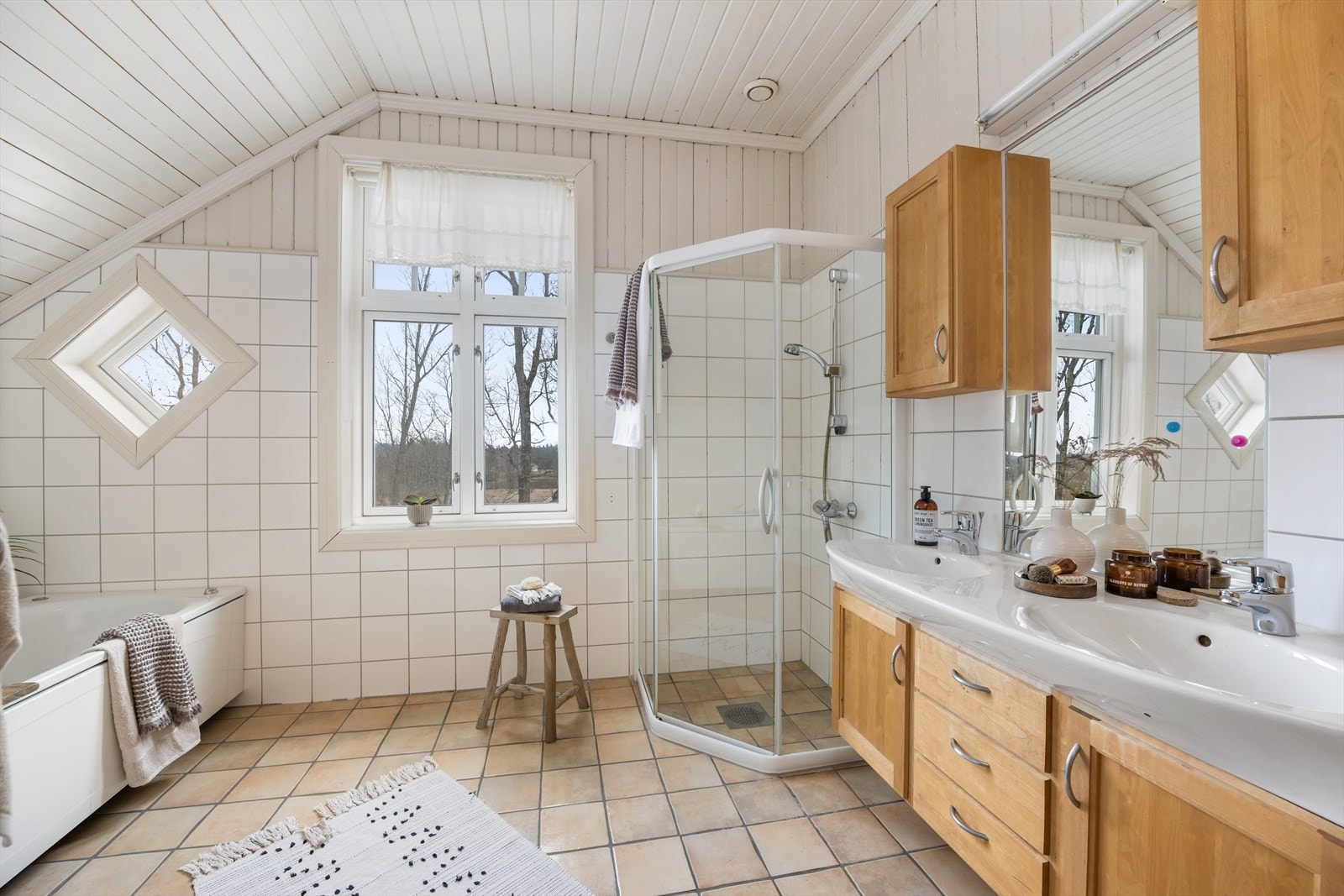 Bad med fliser på gulv og fliser på deler av vegg + panel. Galleribilde