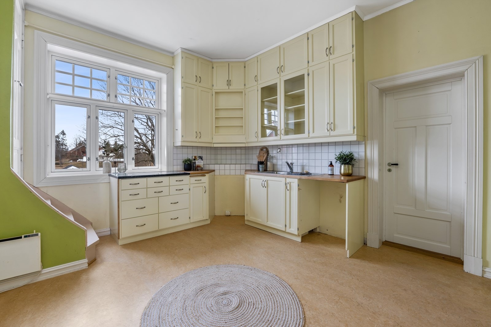 Kjøkken med malt innredning, dør med trapp opp til 2 etg. Galleribilde