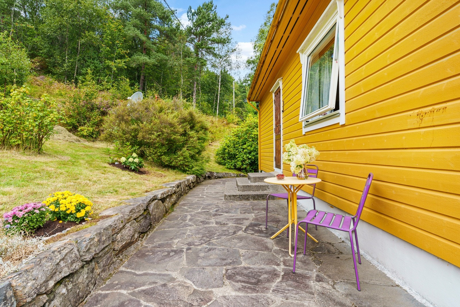 Hellelagt platning utenfor inngangspartiet på oppsiden av boligen Galleribilde