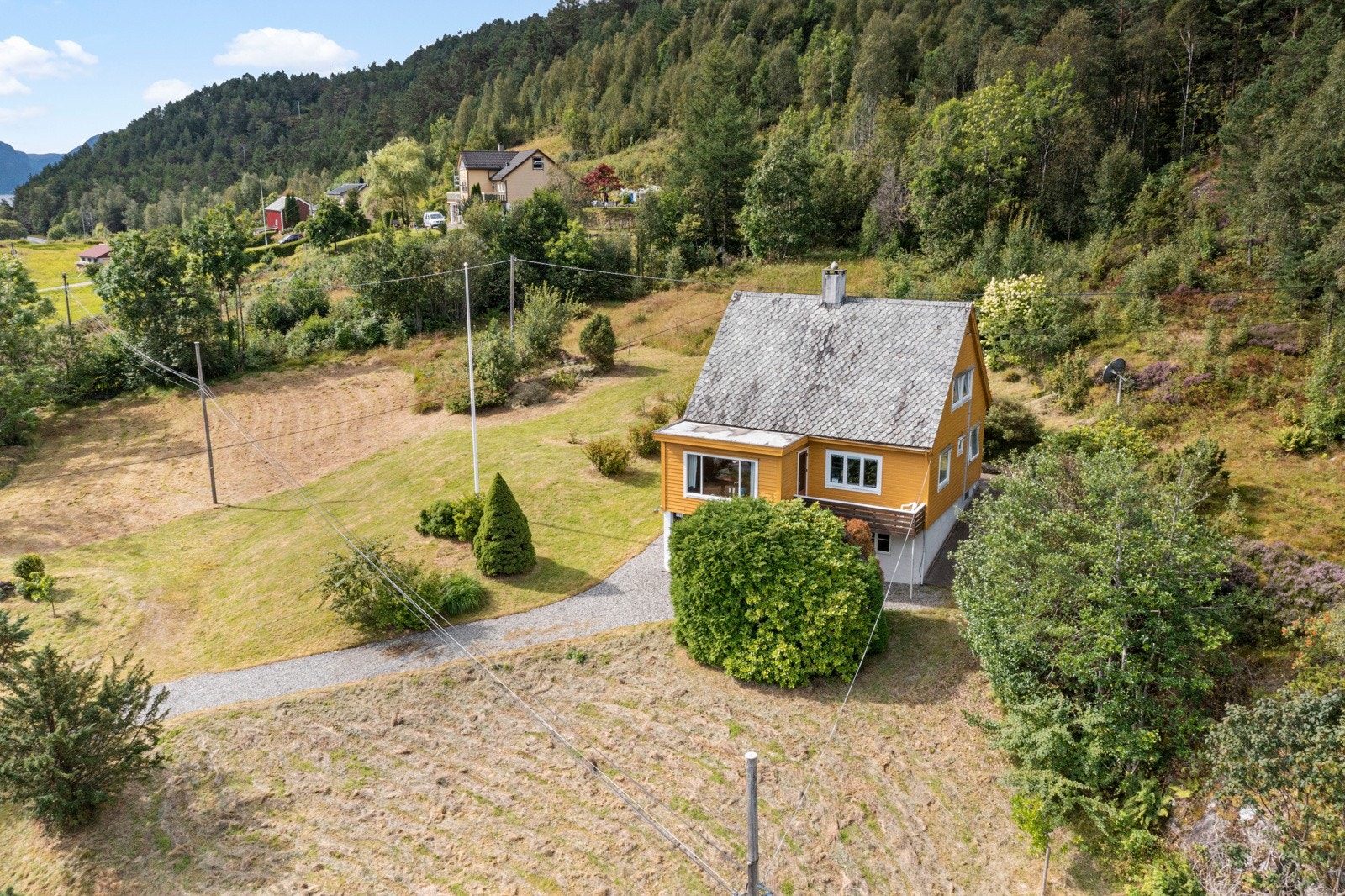 Rundt boligen er det opparbeidet hage med bla. frukttrær og bærbusker Galleribilde