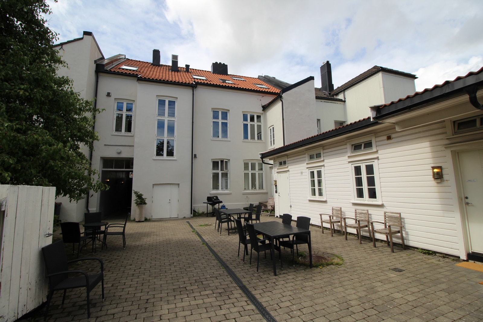 Flott solrik bakgård med sittegrupper Galleribilde