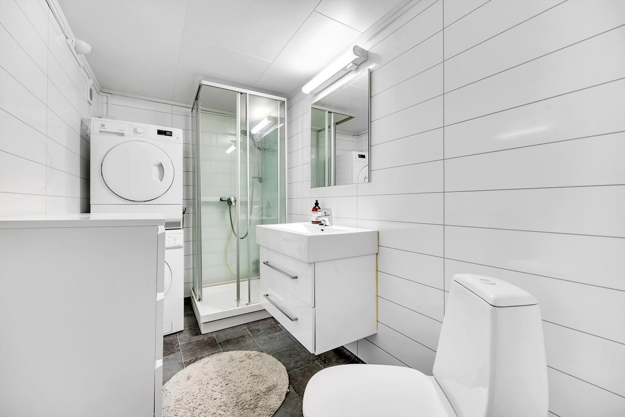 Bad med dusjkabinett med vaskerom, tørketrommel og oppbevaring Galleribilde