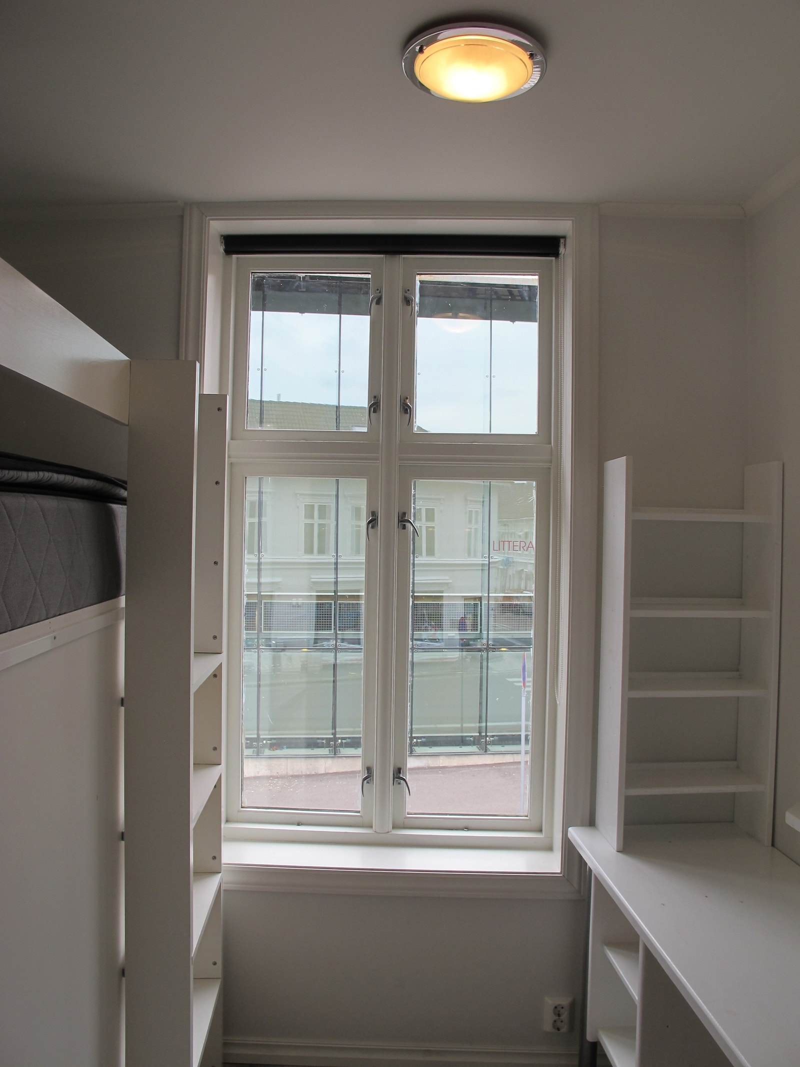 Det store vinduet har utsikt mot biblioteket. Til høyre er det en integrert arbeidspult med hyller til f.eks. bøker. Galleribilde