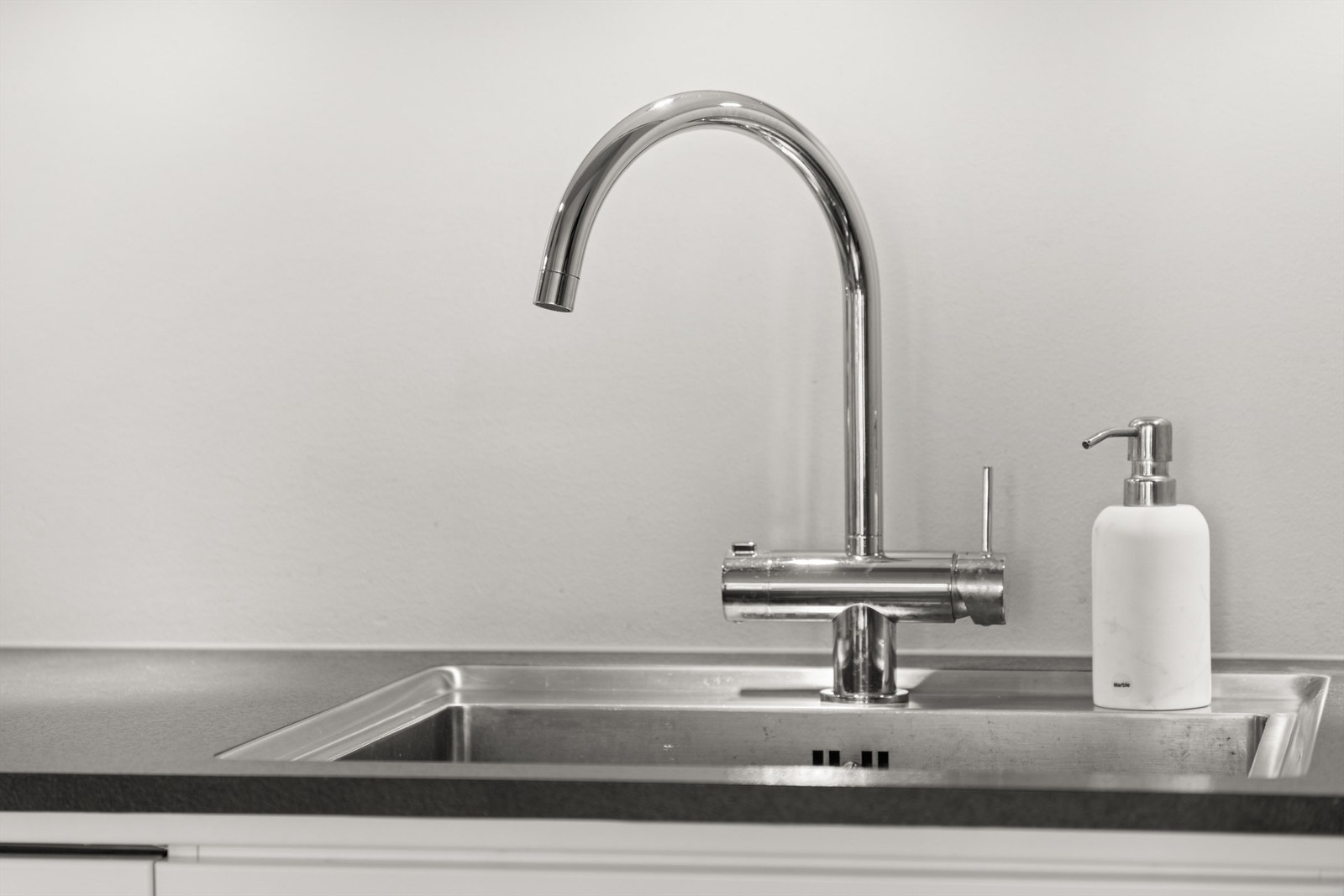 Oppgradert benkeplate i stein med nedfelt oppvaskkum i rustfritt stål og ett-greps armatur. Galleribilde