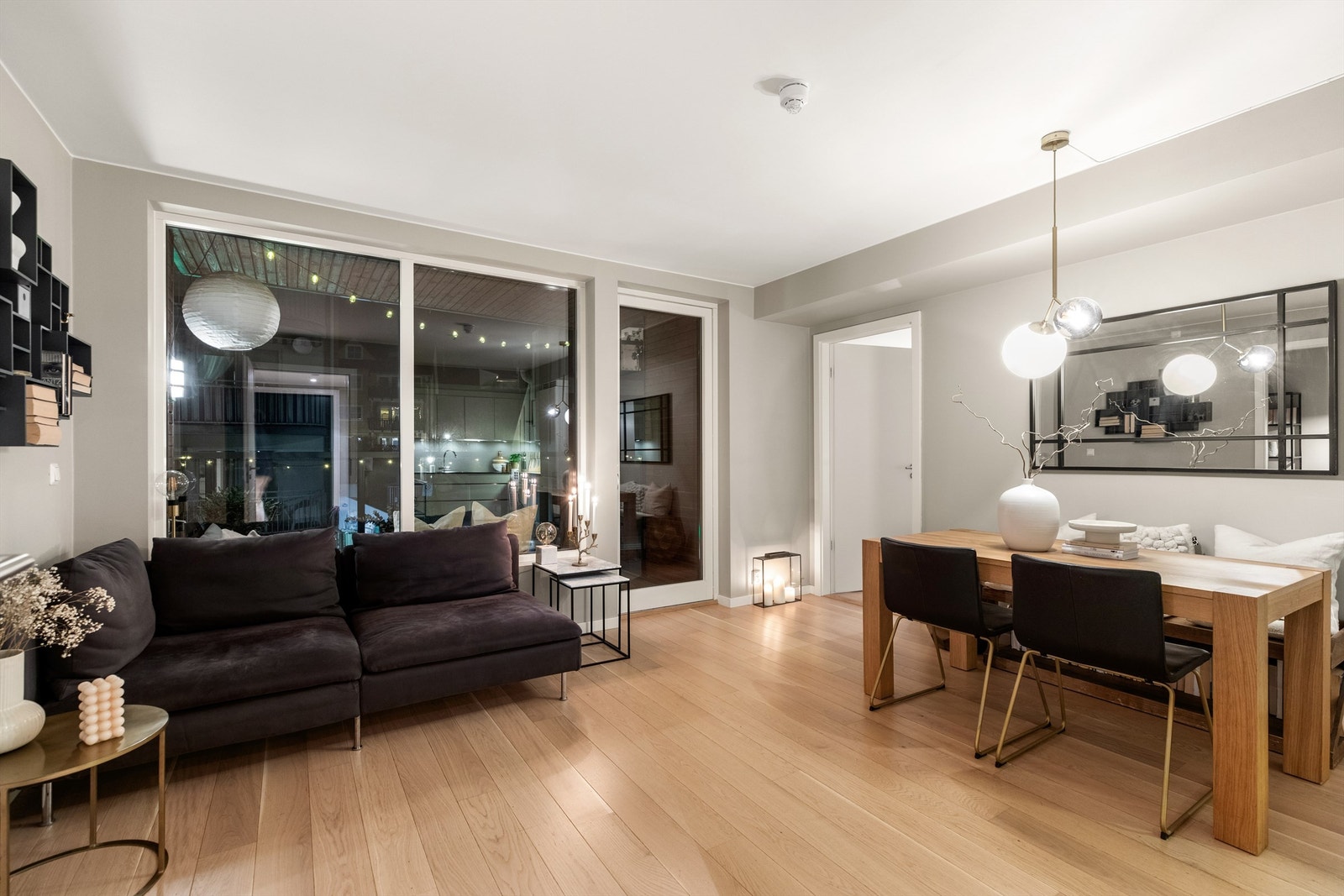 Lys og fin stue med 1-stavs eikeparkett på gulvet og slette veggflater malt i en lun gråtone. Galleribilde