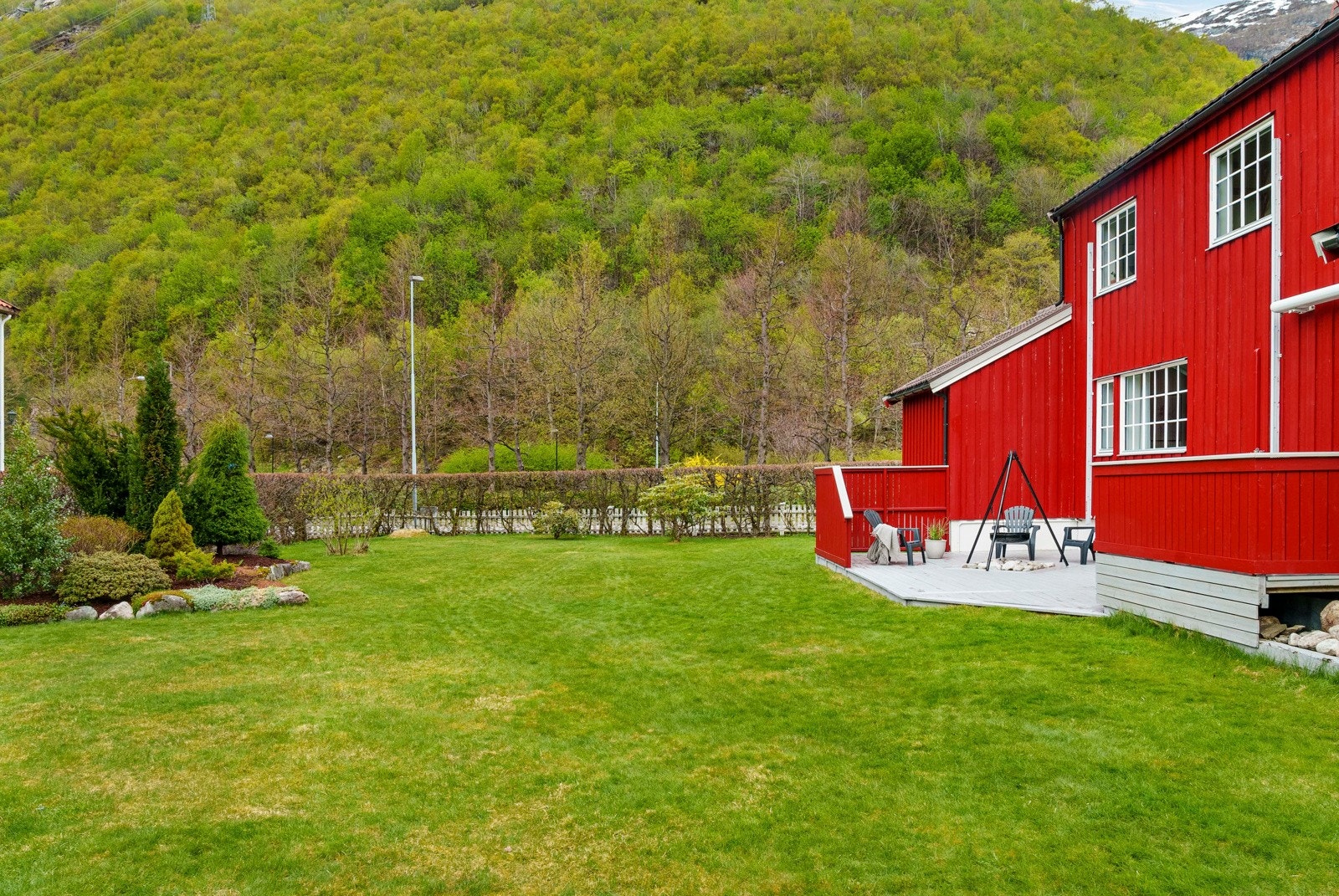 Hagen er pent opparbeidet med plen, hekk mot gata, samt tilplanta bed med kantstein Galleribilde