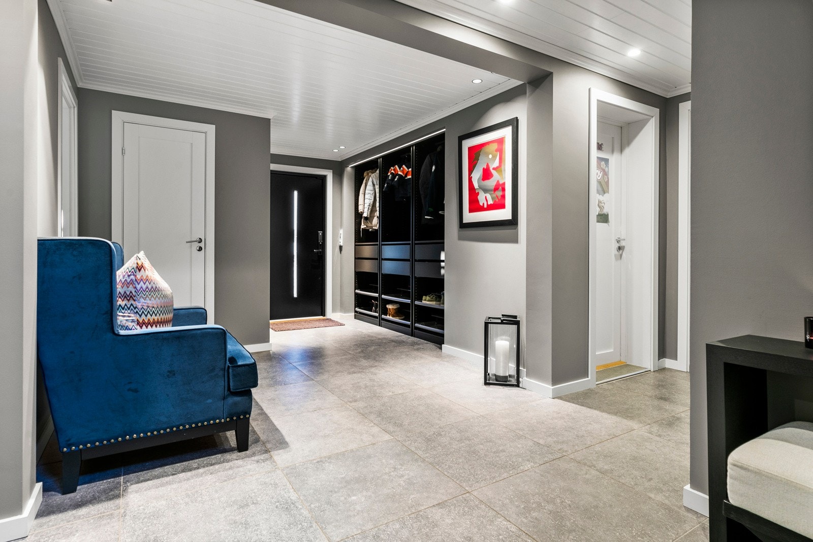Entré/hall med store, tiltalende fliser med varmekabler og garderobeskap Galleribilde