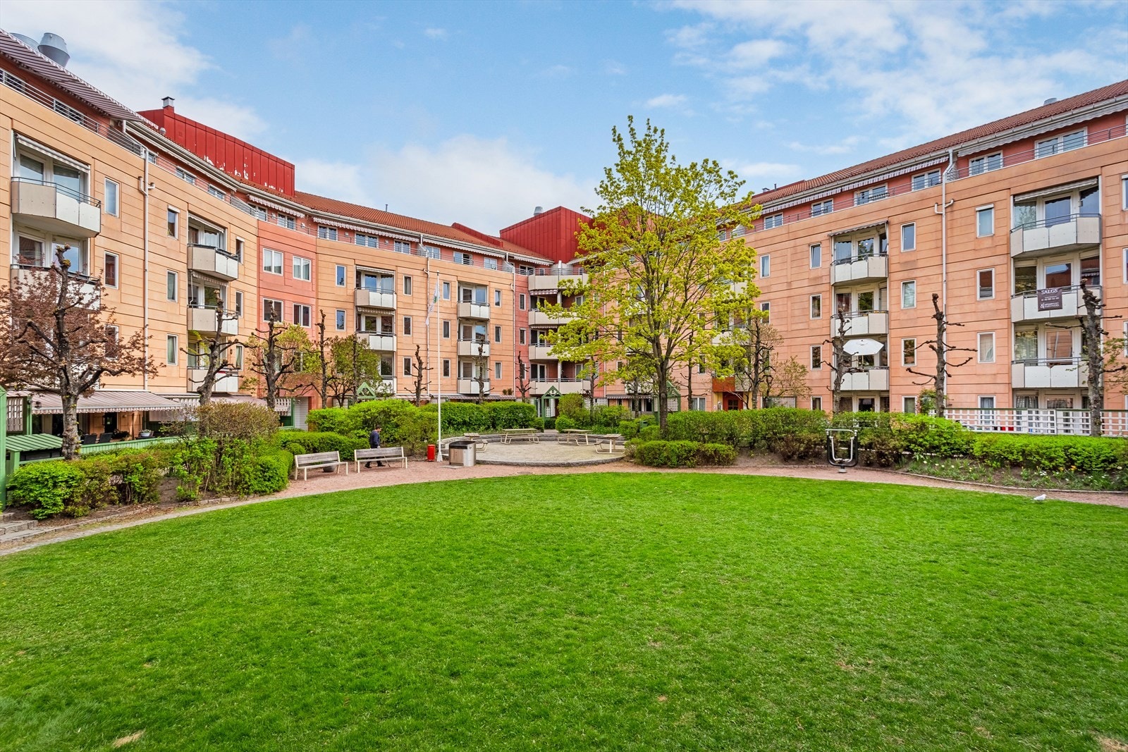 Flott lukket gårdsrom med sittebenker, beplantning, lekeapparat og fellesgrill Galleribilde