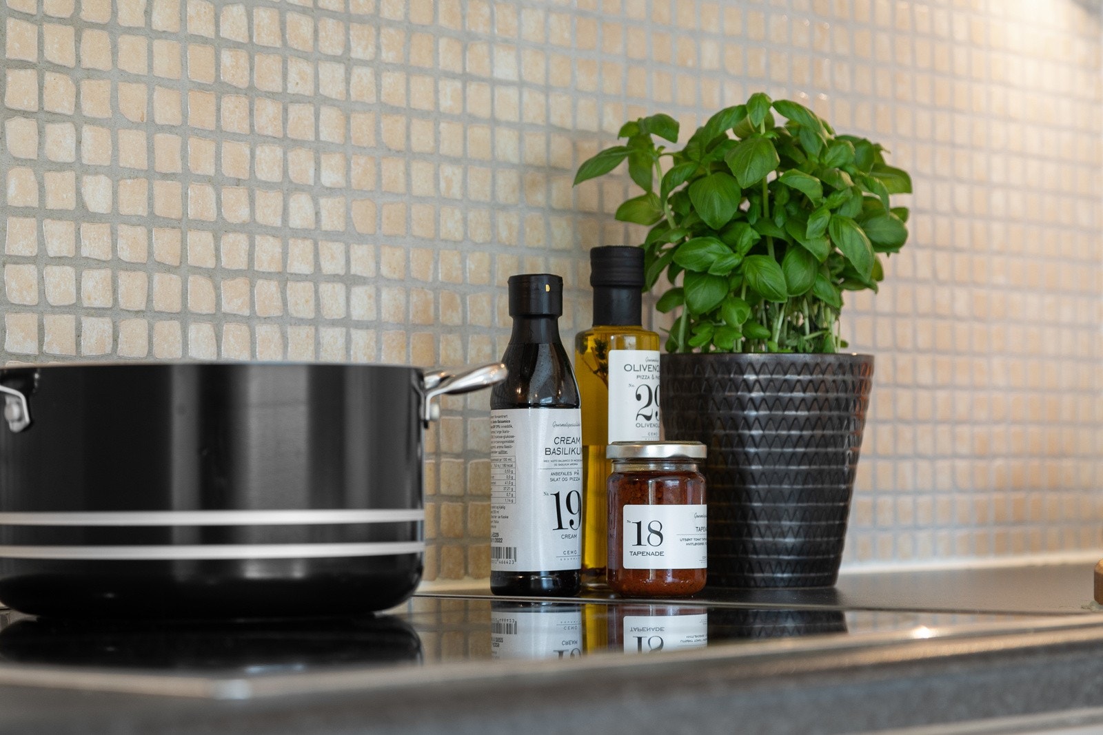 Overskap med benkebelysning og lyse mosaikkfliser på vegger Galleribilde