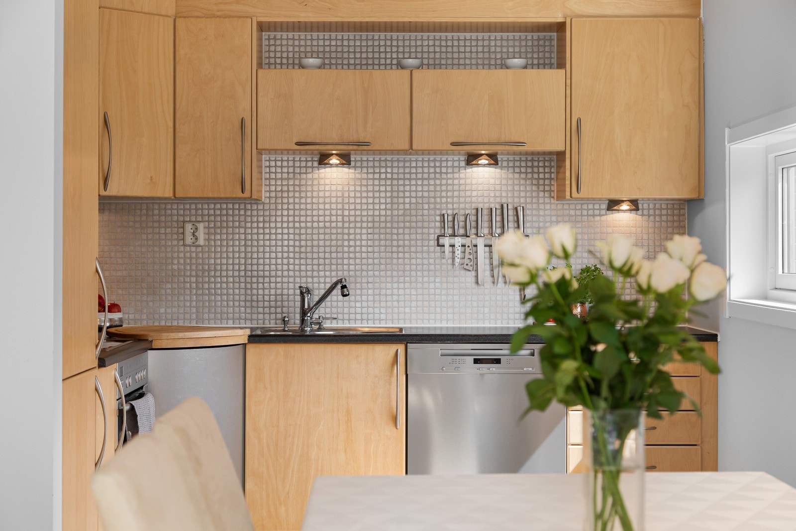 Integrerte hvitevarer som oppvaskmaskin med børstet stålfront fra Miele, kjøl/frys fra AEG samt stekeovn og platetopp fra Bosch Galleribilde