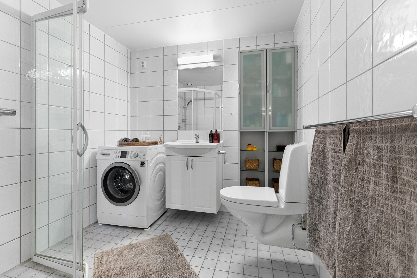 Flislagt bad med gulvvarme samt opplegg for vaskemaskin og tørketrommel Galleribilde