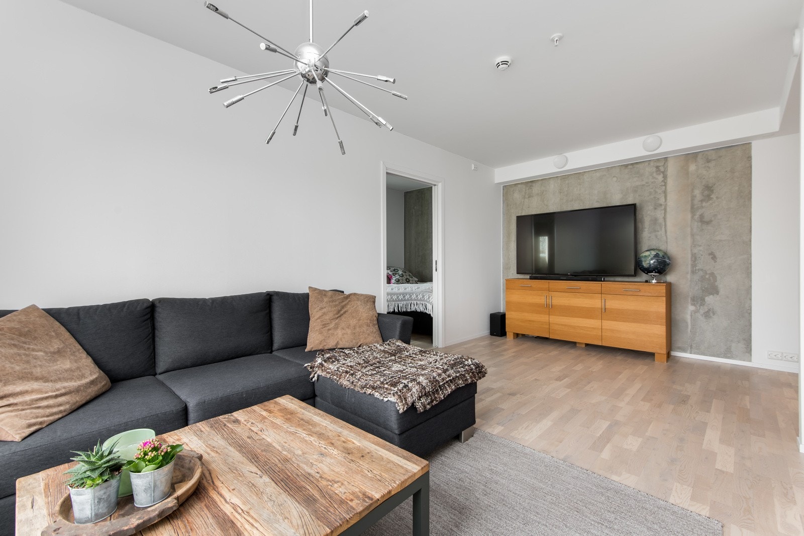 Den ene stueveggen har eksponert betong, som skaper en flott og moderne kontrast til de lyse overflatene Galleribilde