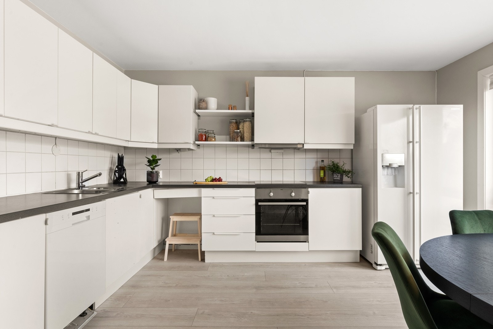 Tidsriktig kjøkkeninnredning med glatte fronter. Fliser mellom benk og overskap forenkler rengjøring. Galleribilde