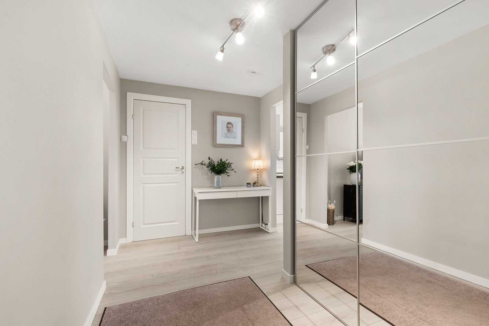 Innbydende entré med plass til knaggrekker og skohyller. Romslig skyvedørsgarderobe med speilfronter for ytterligere lagringsplass. Galleribilde