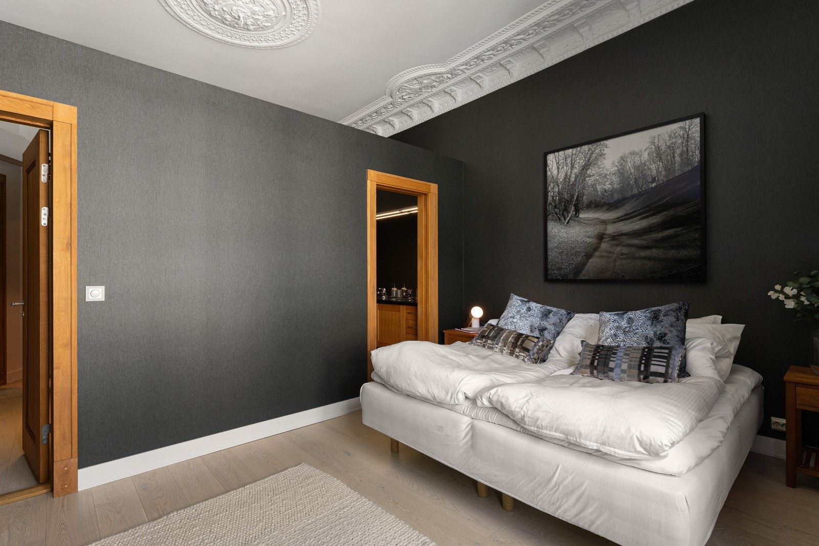 Det er direkte adkomst fra soverommet til bad, via et rom med dobbel servantinnredning. Langs en av veggene har soverommet garderobeskap i eikestruktur med fire glatte fronter. Galleribilde