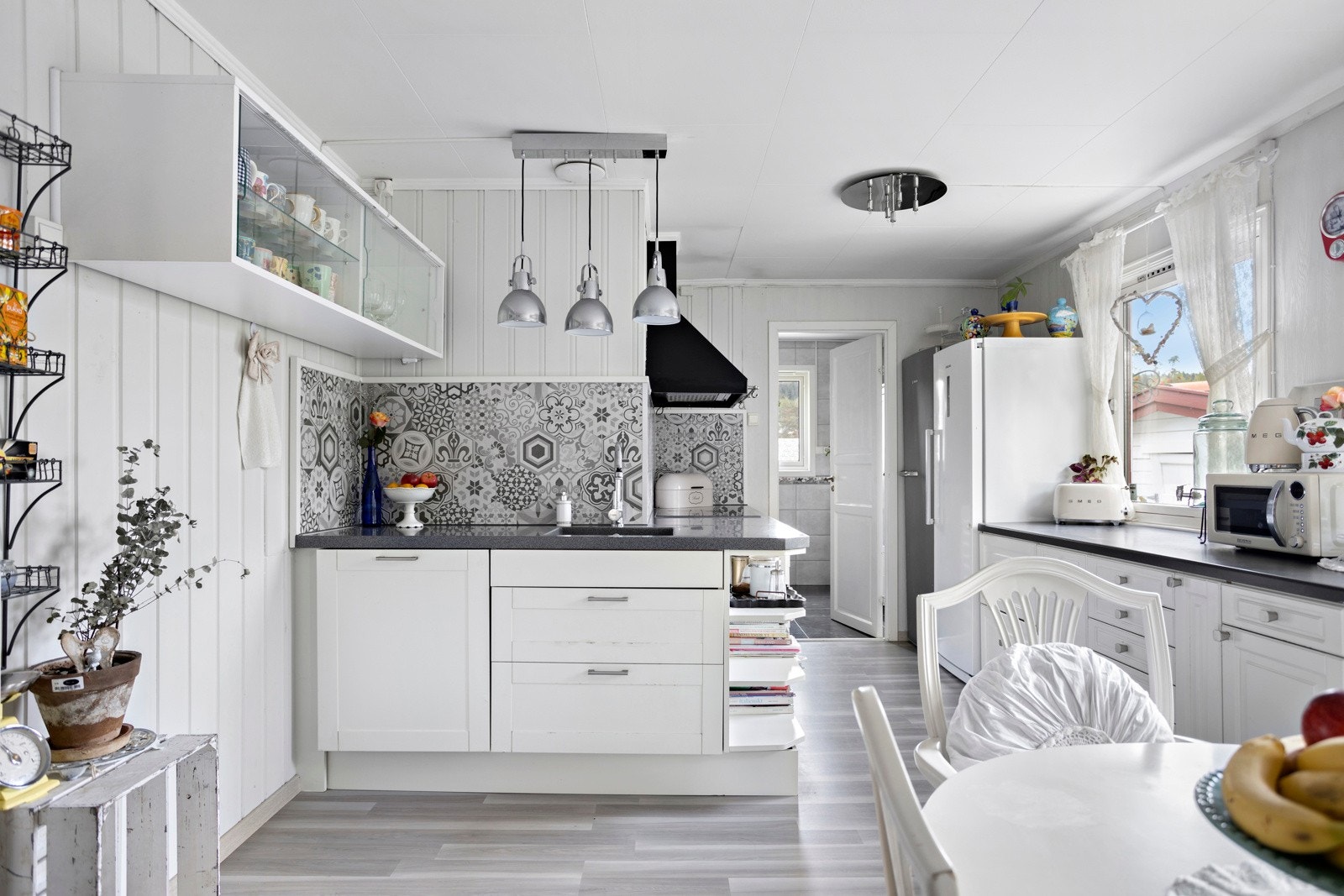 Kjøkkenet fremstår som delikat og praktisk med god skap- og benkeplass Galleribilde