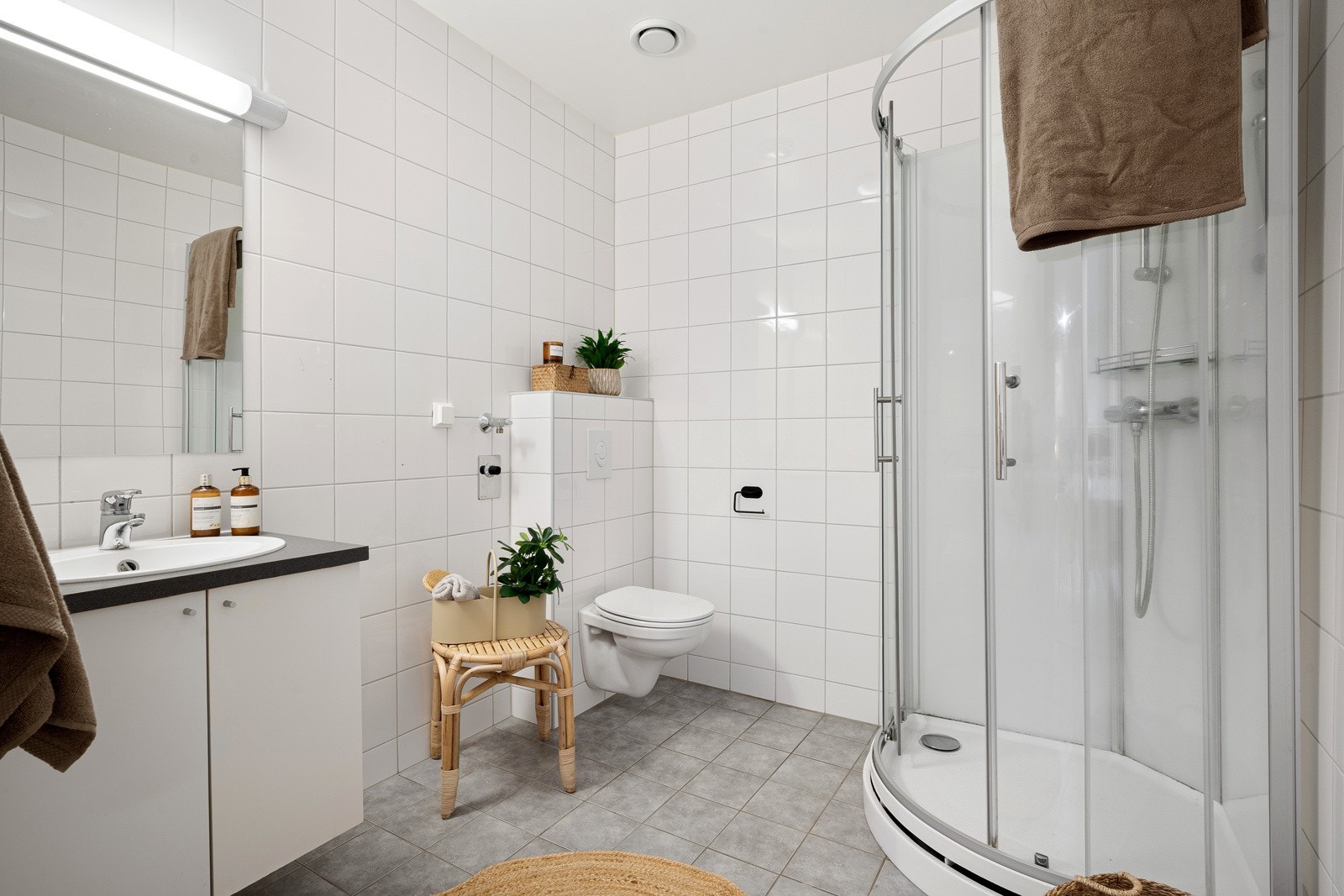 Lekkert, flislagt bad på 5 m² med varmekabler i gulv og vegghengt toalett, samt opplegg for vaskemaskin Galleribilde