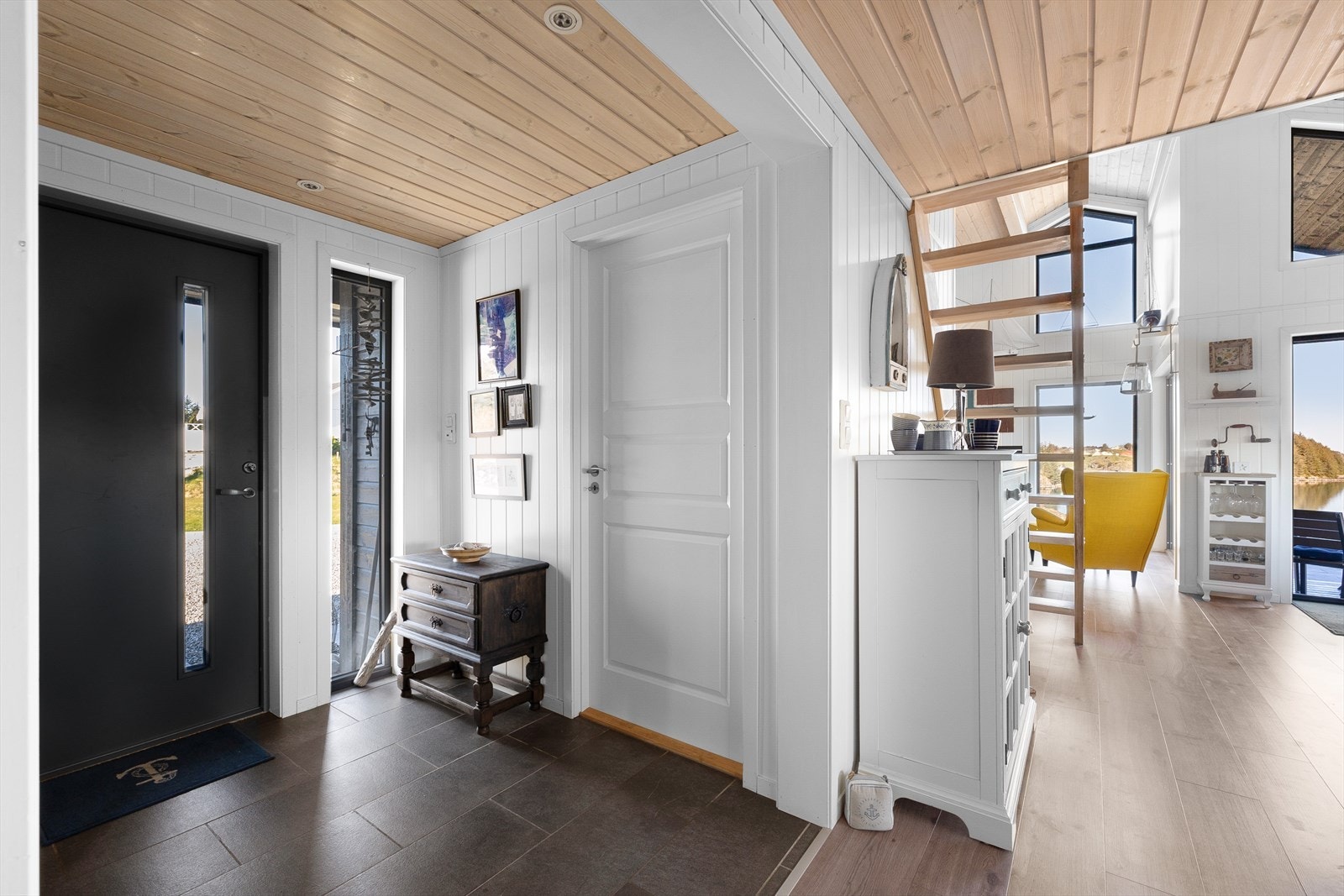 Fin entré på ca 4,8 m² med fliser på gulv, downlights i tak og malte plater på vegger. En stående vindu i full høyde gjør det lyst og trivelig Galleribilde