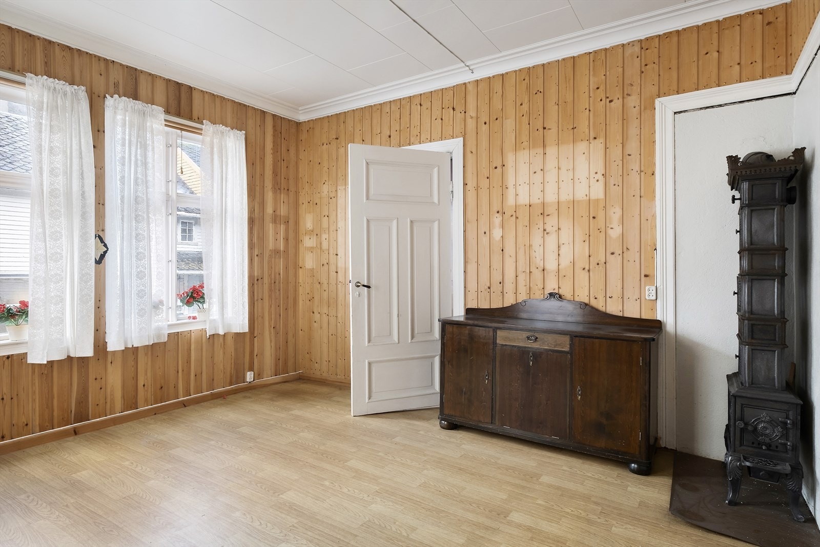 Frå stova har ein utsyn mot Øyragata 48 og flott etasjeomn montert i rommet Galleribilde