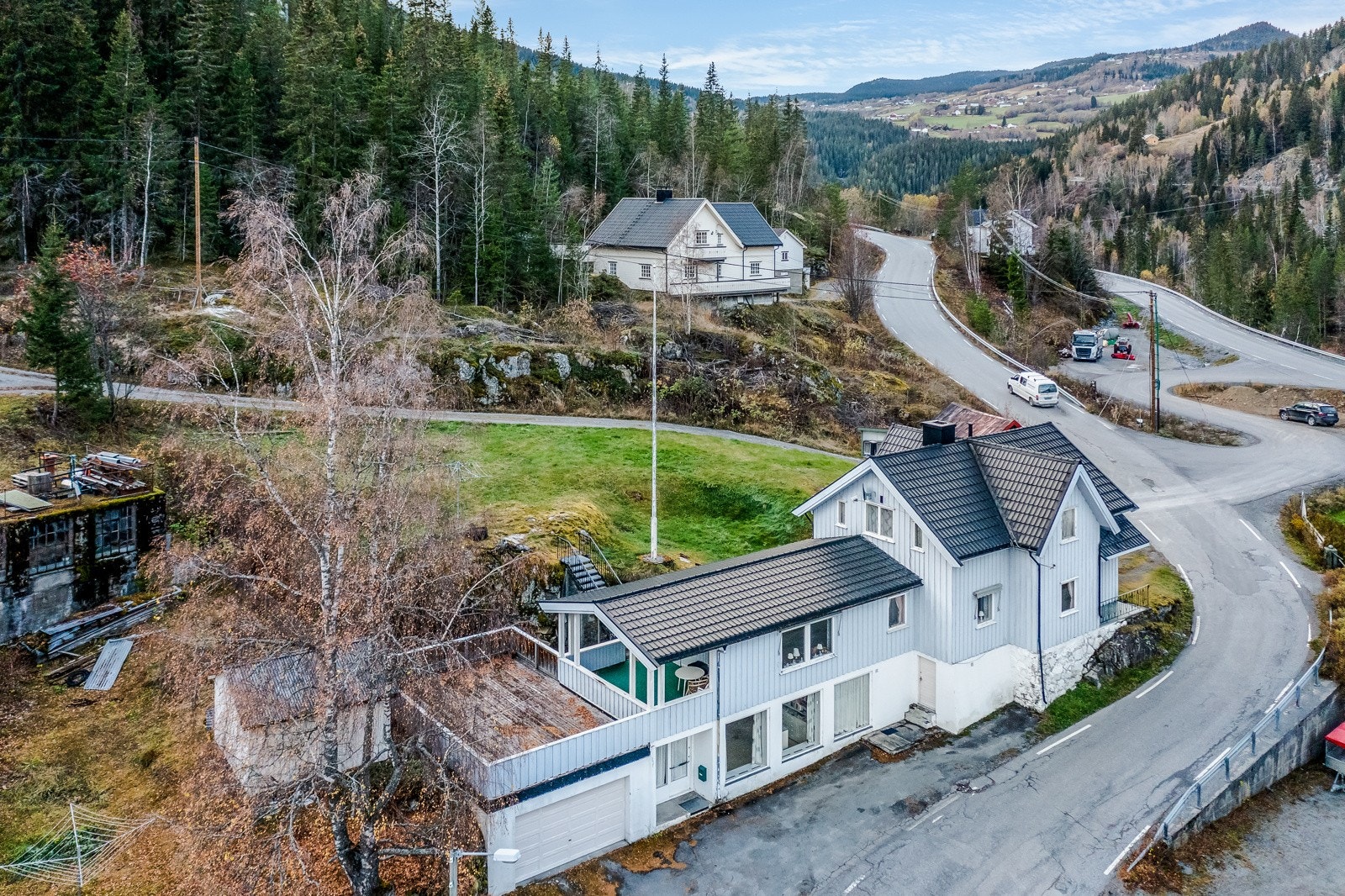 Inntil forretningslokalet er det garasje med plass til en bil. Garasjen har port og det er laget terrasse på taket av den. Galleribilde