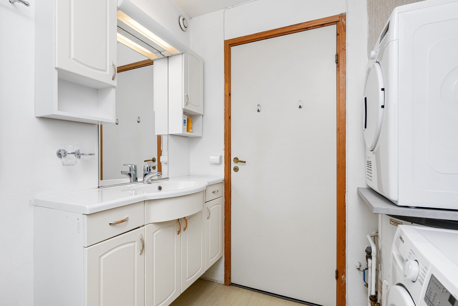 Badet har god størrelse, med god plass til veggskap og vaskemaskin/tørketrommel Galleribilde