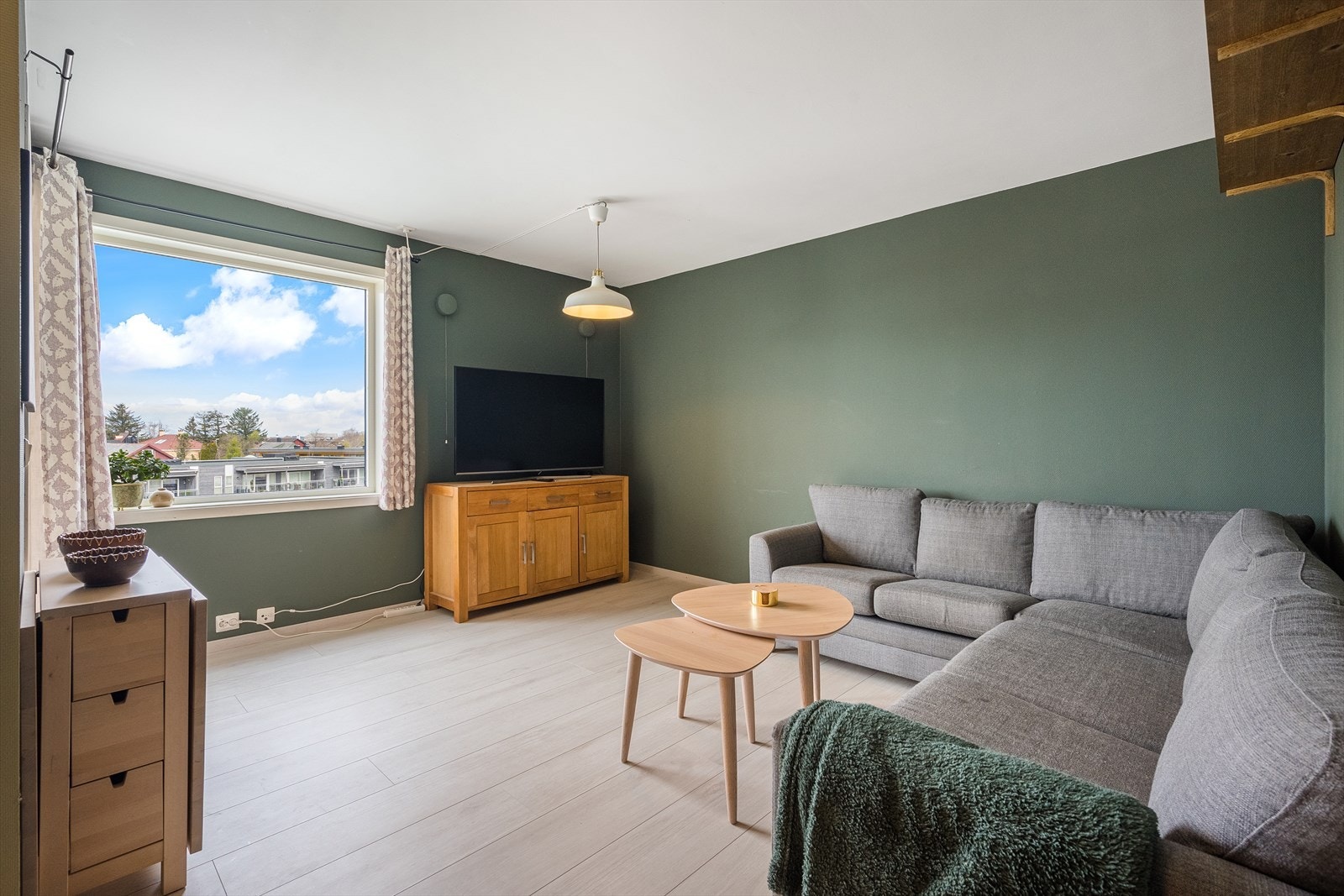 Lys stue med malte overflater og laminat på gulv. Galleribilde