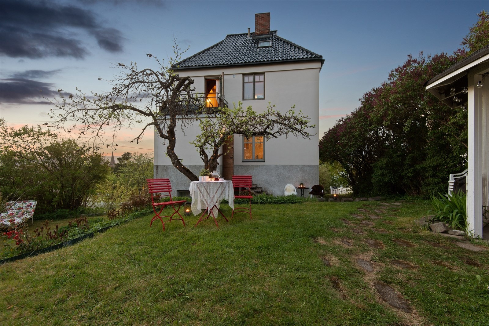 Delvis skrående tomt med opparbeidet plen og beplantning. Galleribilde